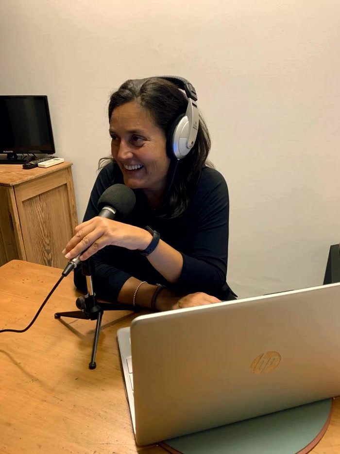 Andrea Cruz ajustando el micrófono en el estudio